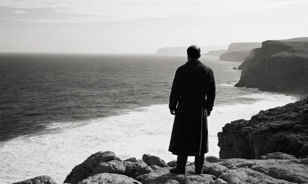 A black and white image capturing a solitary figure standing on a rocky cliff, their face hidden, symbolizing biblical characters who faced discipline and sought redemption through solitude and reflection.