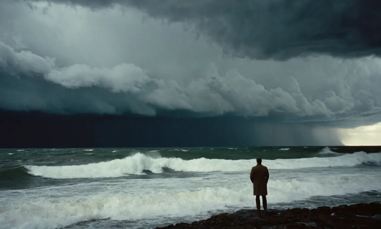 A photo capturing a solitary figure standing at the edge of a vast, turbulent ocean, their gaze fixed on the raging storm clouds overhead, symbolizing the insignificance of human struggles in the face of nature's might.