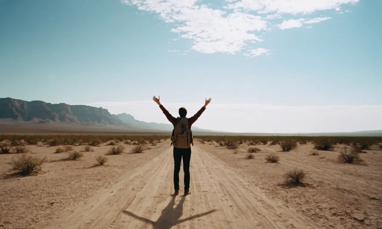 A photograph capturing a person standing alone in a barren desert, their outstretched arms reaching towards the sky, symbolizing the idea that God provides necessities rather than fulfilling our desires.