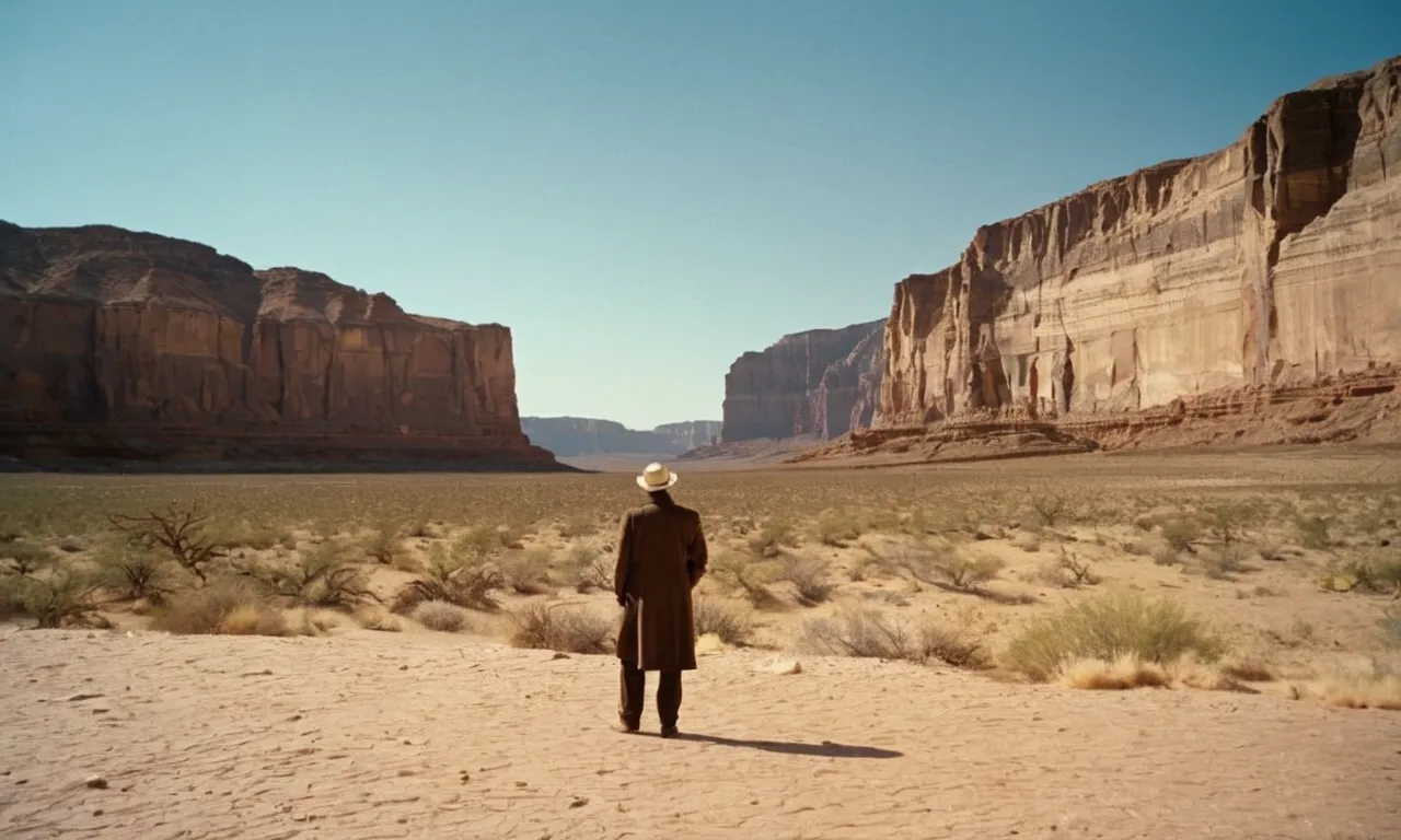 A photo capturing the vastness of the desert, with a lone figure standing at the base of towering sandstone cliffs, symbolizing the awe-inspiring presence of the biblical watchers.
