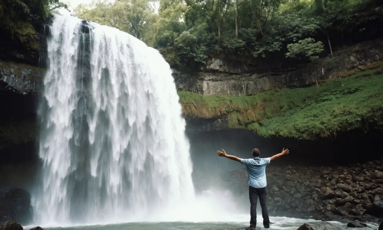 A photo of a person standing under a cascading waterfall, arms outstretched, eyes closed, as the powerful rush of water symbolizes God's purifying and cleansing grace.