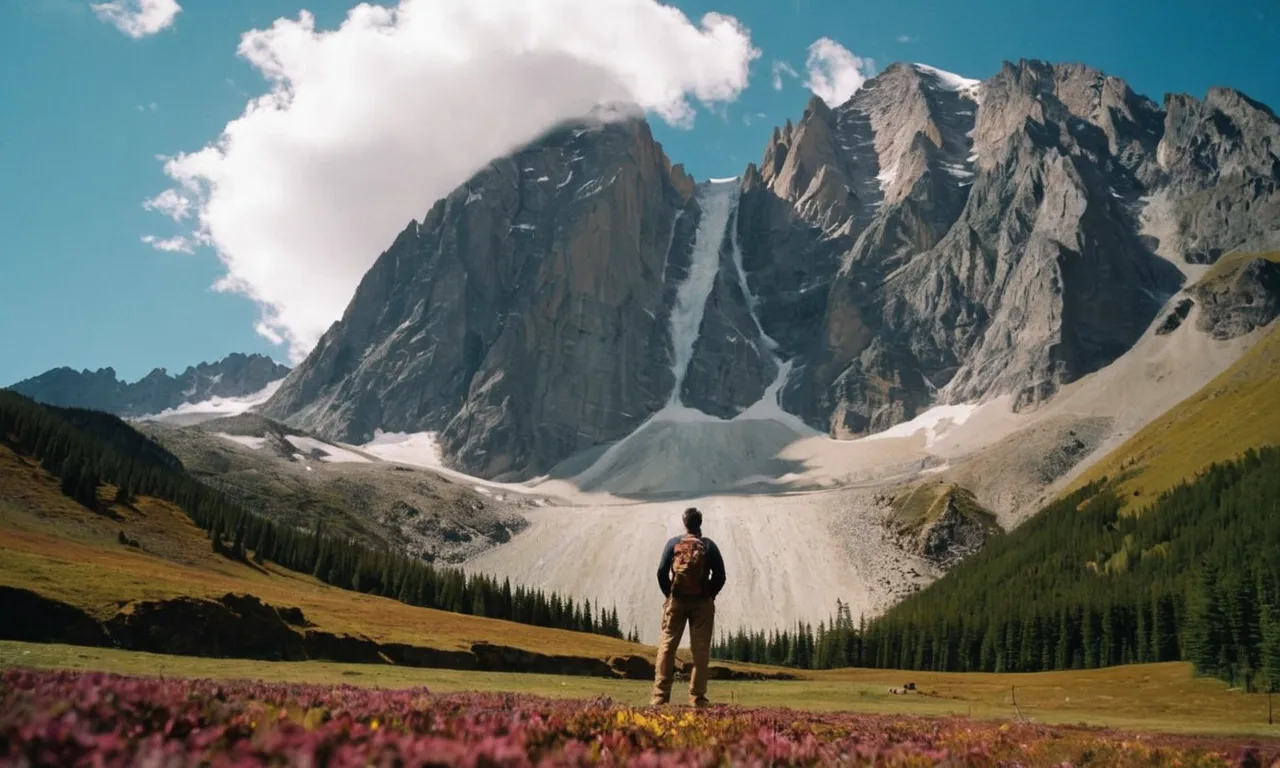 A photo capturing a tiny figure standing at the base of a towering mountain range, symbolizing the awe-inspiring stature of the giants mentioned in the Bible.