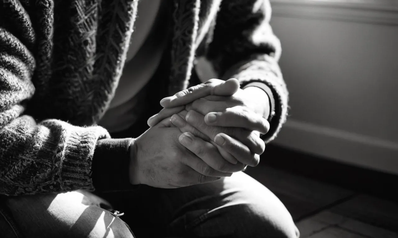 A black and white photograph captures a person kneeling in prayer, their hands clasped together, bathed in soft light, symbolizing unwavering faith and devotion to God.
