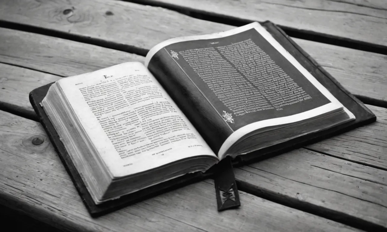 A black and white photo capturing an open Bible resting on a weathered wooden table, surrounded by worn-out pages and a pair of folded hands, symbolizing humility and reverence towards the Word of God.
