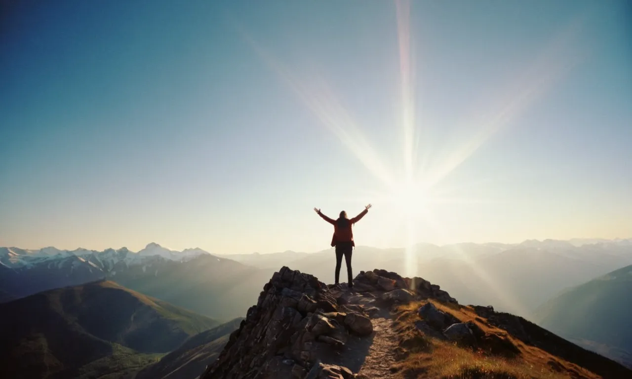 A photo of a person standing on a mountain peak, arms outstretched, with a radiant beam of light shining down, symbolizing the spiritual act of pleading the blood of Jesus for protection and empowerment.
