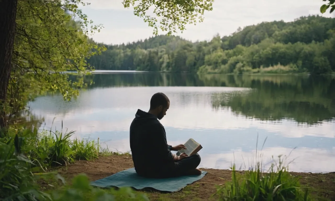 A serene image of a person sitting cross-legged by a tranquil lake, surrounded by lush greenery and gently holding a Bible, lost in deep contemplation, connecting with God's presence.
