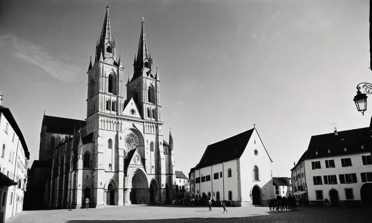 A black and white photo of a majestic cathedral standing tall amidst a medieval village, symbolizing the central role of Christianity as the heart and soul of medieval European society.