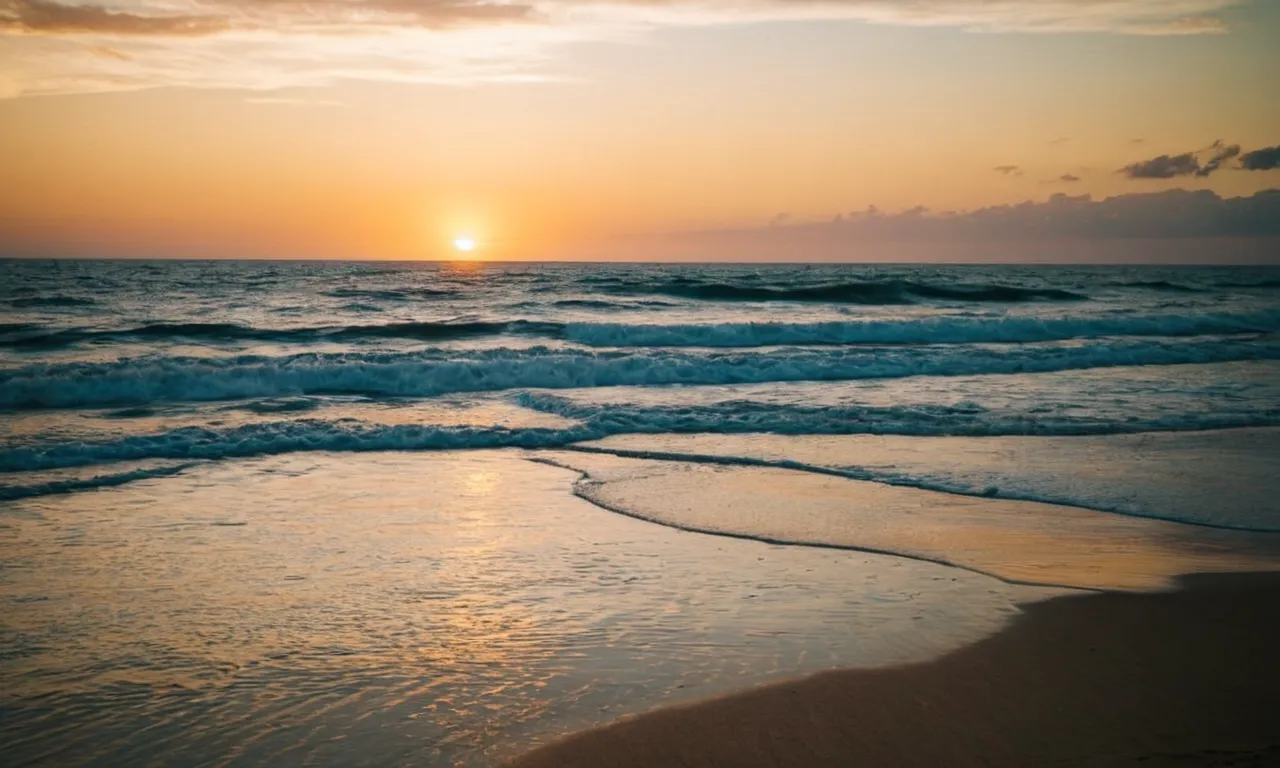 A photo of a stunning sunset over a vast ocean, with the verse "No matter what lies ahead, God is faithful" delicately written in the sand.