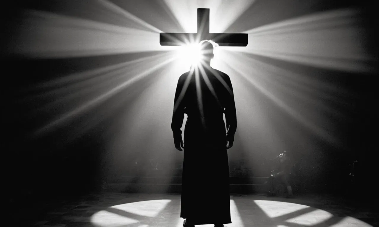 A black and white photo of a person standing in a beam of light, casting a shadow in the shape of a cross, symbolizing being marked by God.
