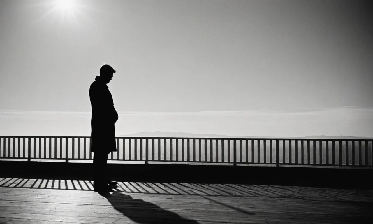 A solemn black and white image captures the silhouette of a solitary figure, symbolizing isolation and the pain of broken trust, echoing the Bible's warnings about friends turning against you.