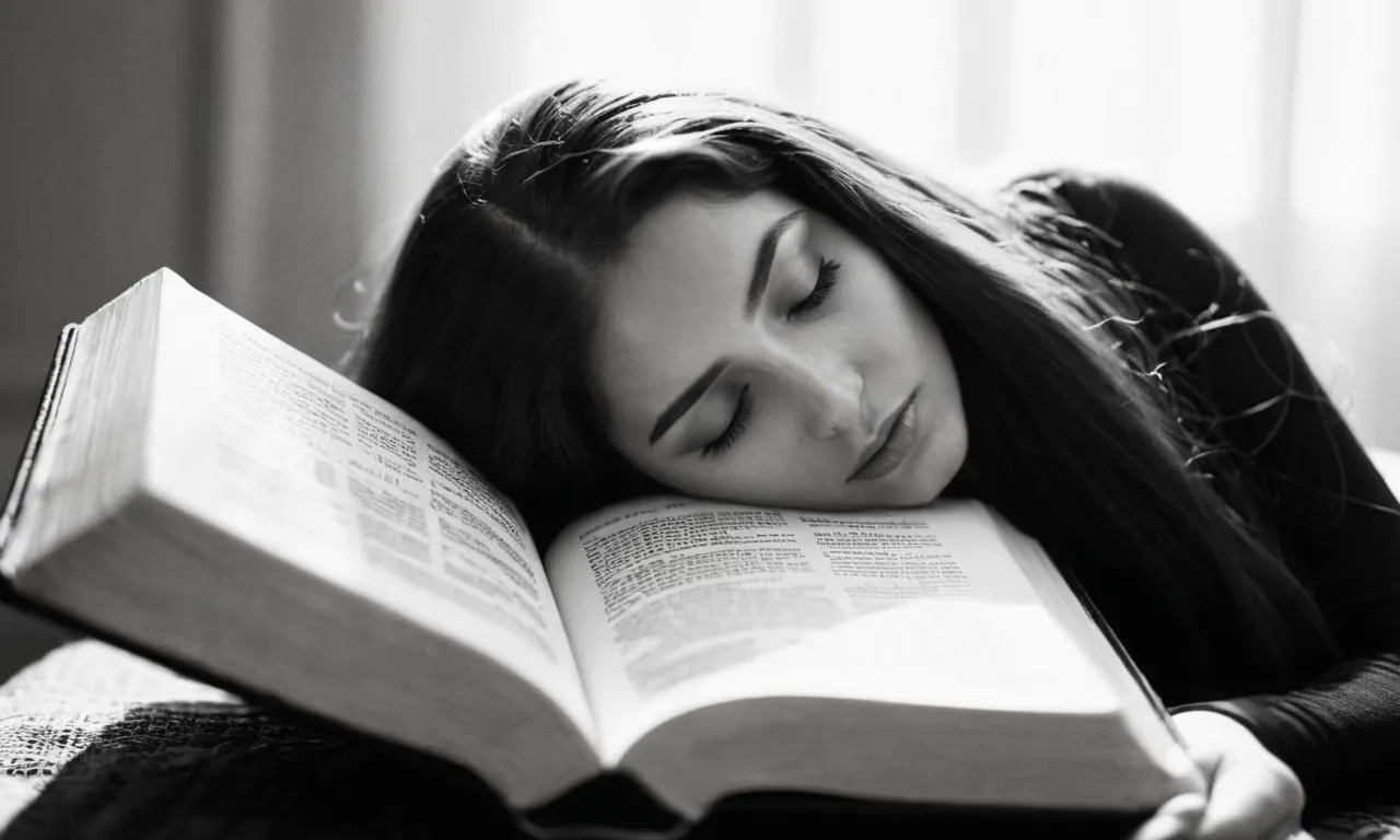 A black and white close-up photograph of a woman's long, flowing hair gently resting on a Bible, symbolizing the beauty and significance of hair as mentioned in the biblical teachings.
