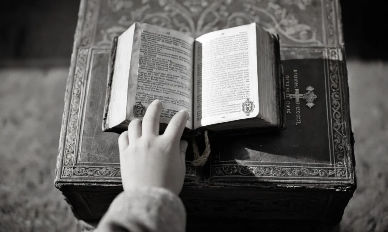 A solemn black and white image captures a pair of tiny hands clutching a worn-out Bible, symbolizing the sacred duty to protect and nurture children, as emphasized by biblical teachings.