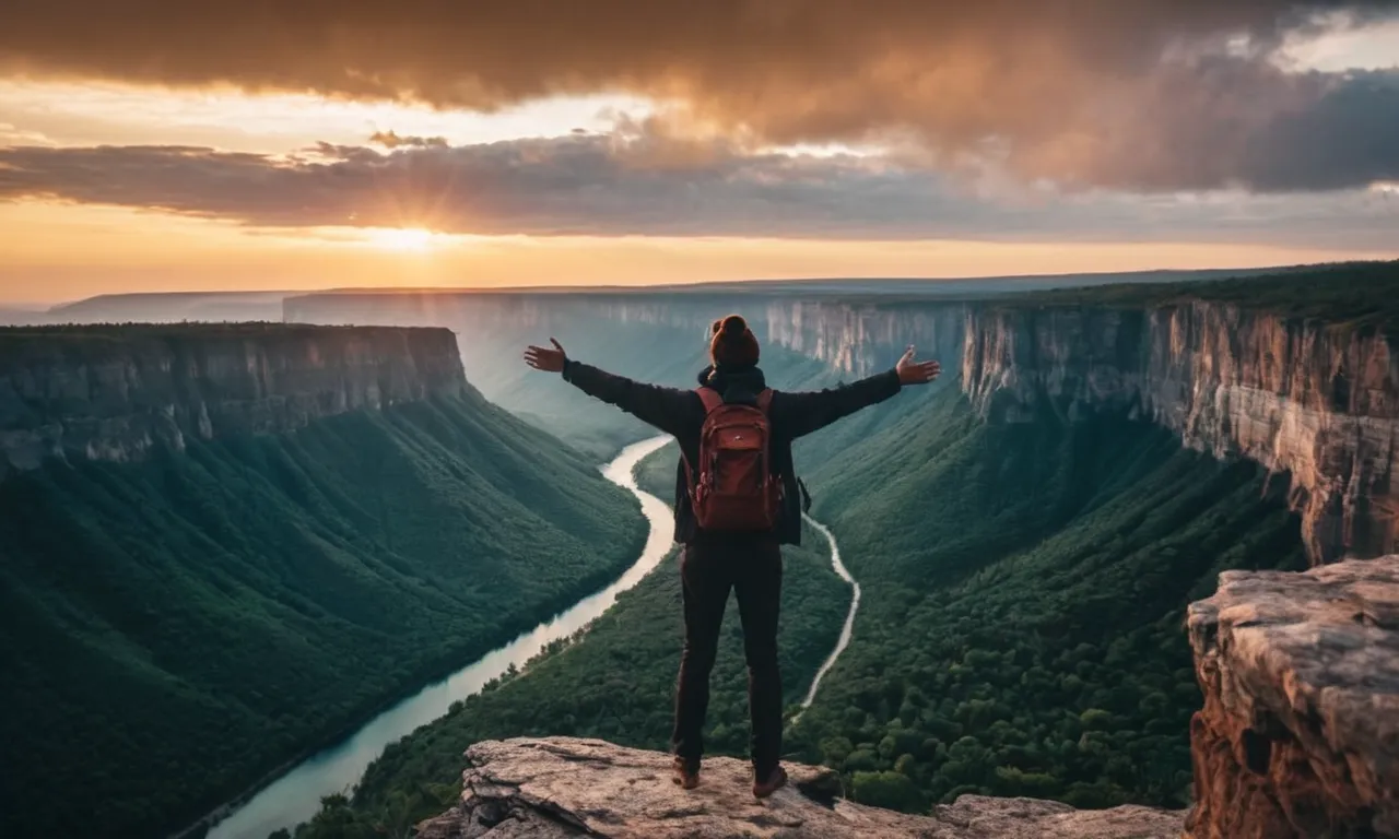 A photo capturing a person standing at the edge of a cliff, with outstretched arms, as a majestic sunrise illuminates a dark sky, symbolizing the power of faith and the limitless possibilities through God.