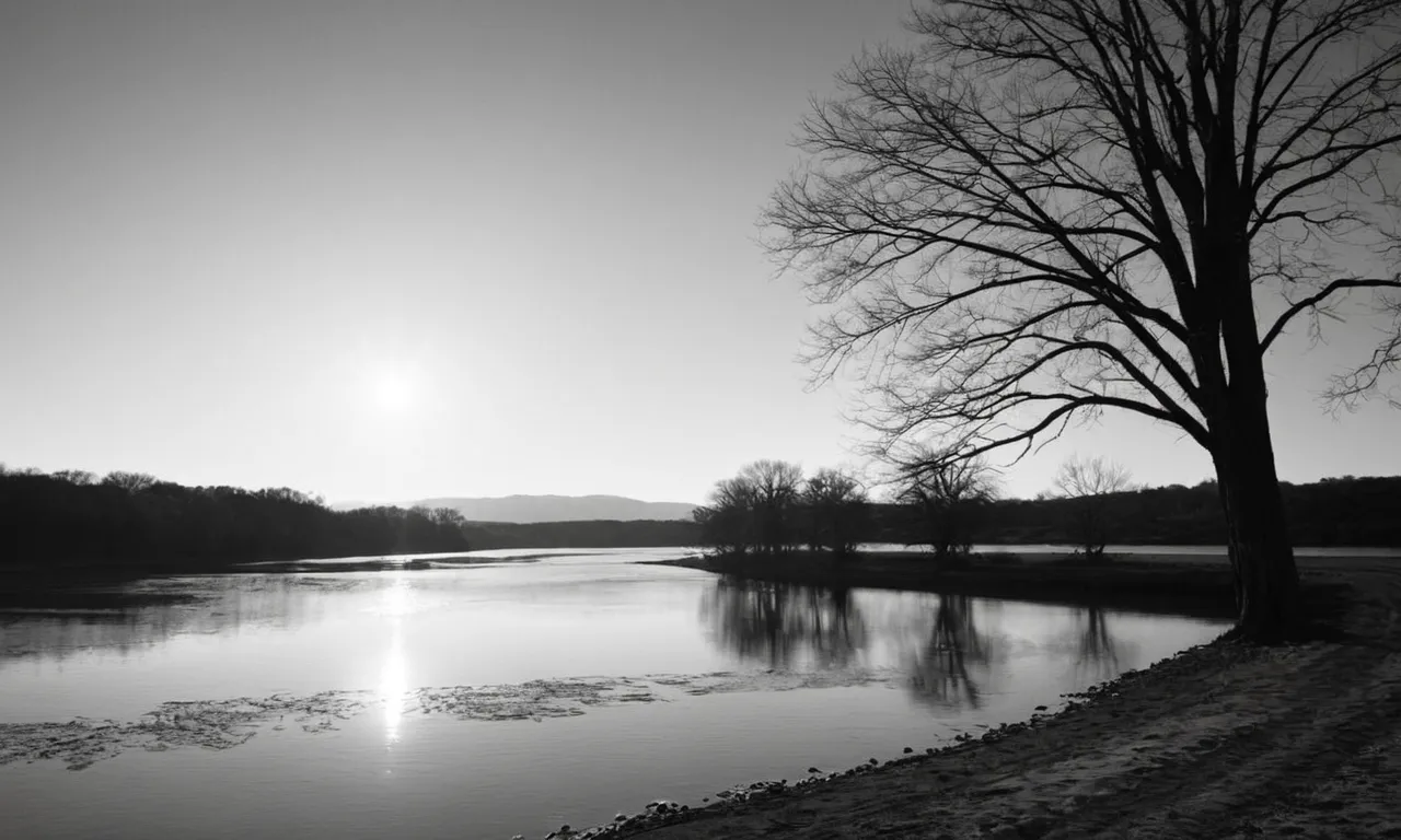 A black and white photograph of a serene, empty river bank at sunrise, capturing the essence of the moment when Jesus began his ministry.