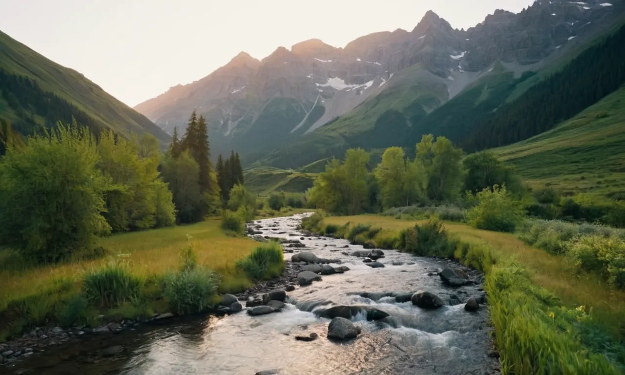A breathtaking photo captures a serene mountain landscape at sunrise, where a stream gently flows through lush greenery, symbolizing God's guidance and provision in the midst of nature's abundance.