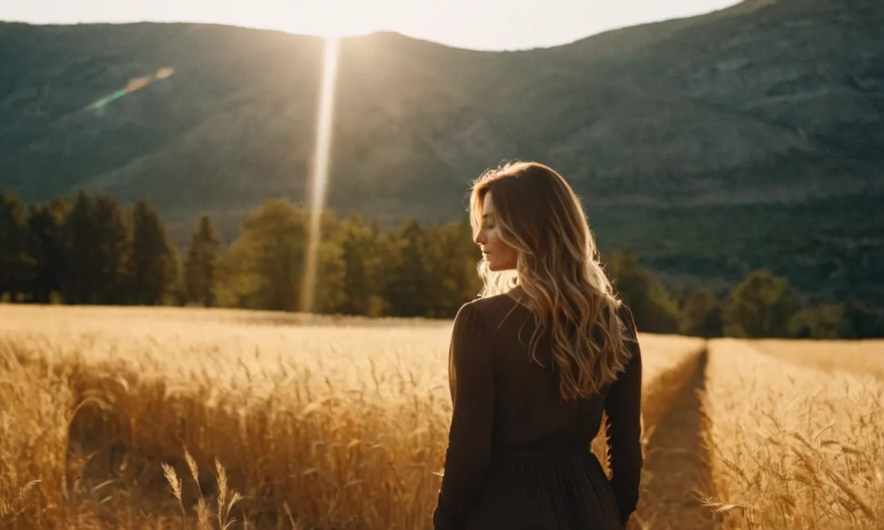 A captivating photo of a woman standing tall amidst a serene landscape, bathed in golden sunlight, reflecting her inner strength and beauty, portraying the answer to "Who does God say I am as a woman?"