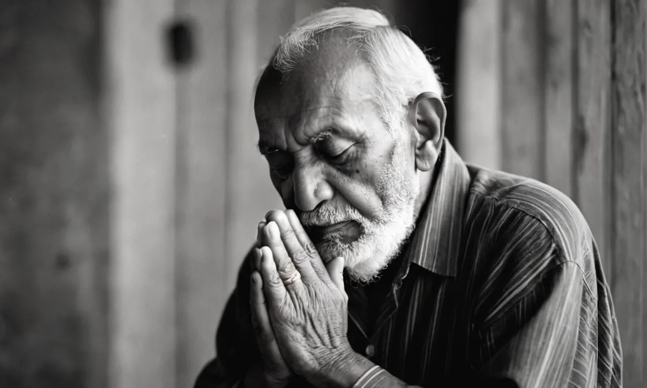 A black and white photo captures a humble elderly man kneeling in prayer, his weathered hands clasped together, his eyes closed in deep devotion, portraying the essence of righteousness before God.