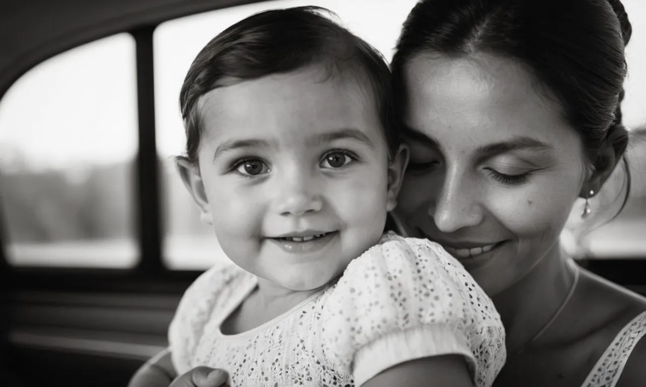 A tender black and white image captures a beaming child cradled in their parent's arms, their eyes sparkling with innocence, a miraculous testament to the divine gift of life.