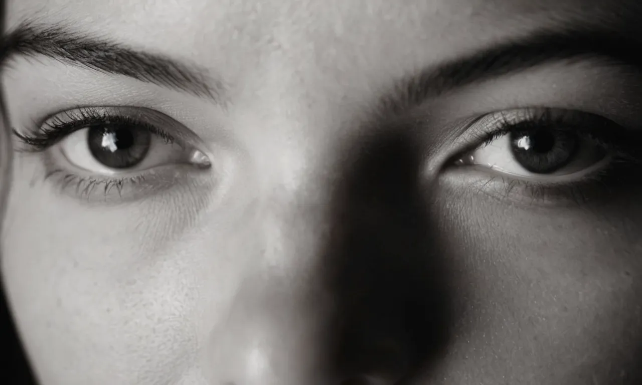 A black and white close-up portrait of a person staring intensely into the camera, their eyes filled with both curiosity and melancholy, questioning why they were uniquely created by a higher power.