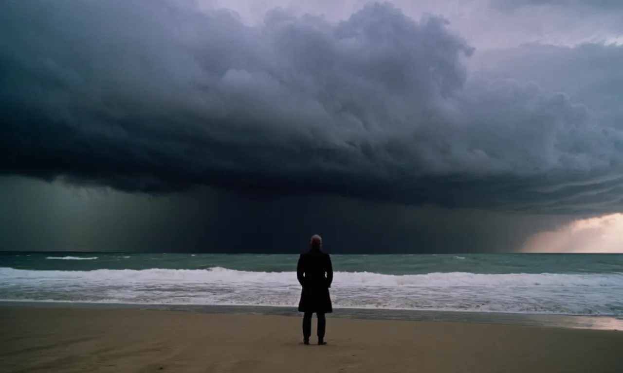A photo depicting a silhouette of a person standing alone on a desolate beach, their head tilted towards the sky as dark storm clouds loom overhead, questioning their worth and longing for divine love.