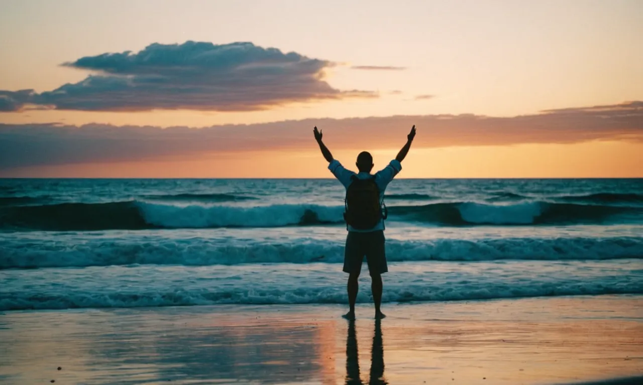 A photo capturing a serene sunset over a vast ocean, with a solitary figure on a beach, arms raised in awe, evoking the question, "Why should we love God?"