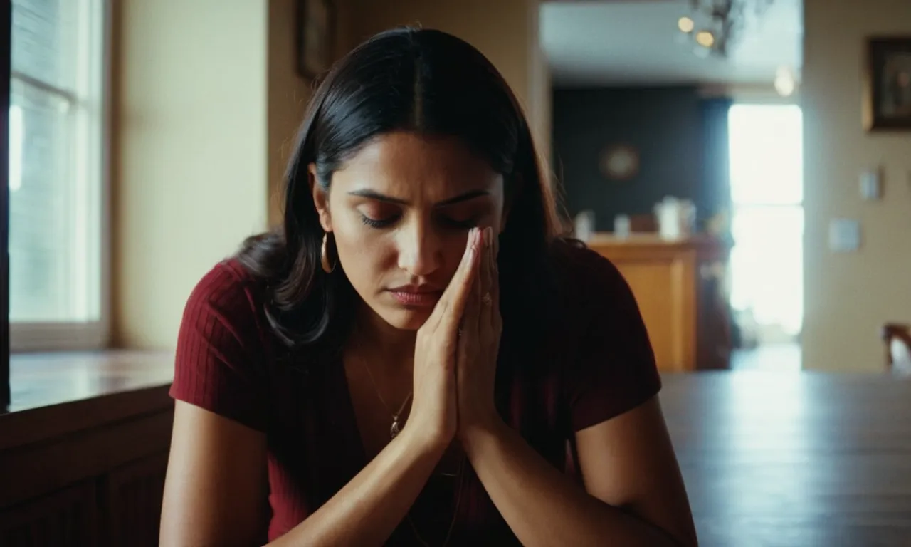 The photo captures a person, sitting in a dimly lit room, with hands clasped and a desperate expression, symbolizing their plea for divine intervention in their financial struggles.